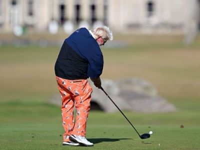 John Daly is hitting the shot as there is a building in the background.